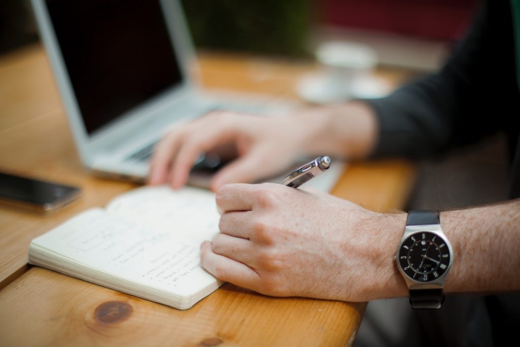 Une personne prenant des notes durant une session de formation